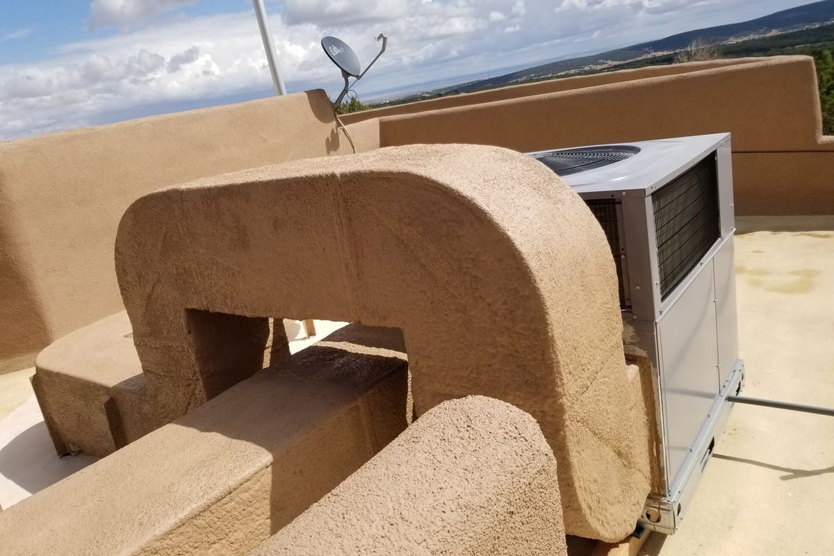 Rooftop ductwork and HVAC unit insulated with spray foam and coated on a flat roof