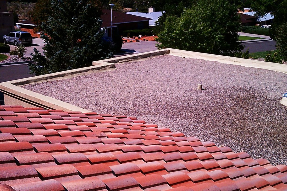 Four Hills home in Albuquerque with a clay tile roof edge and a flat roof area beyond