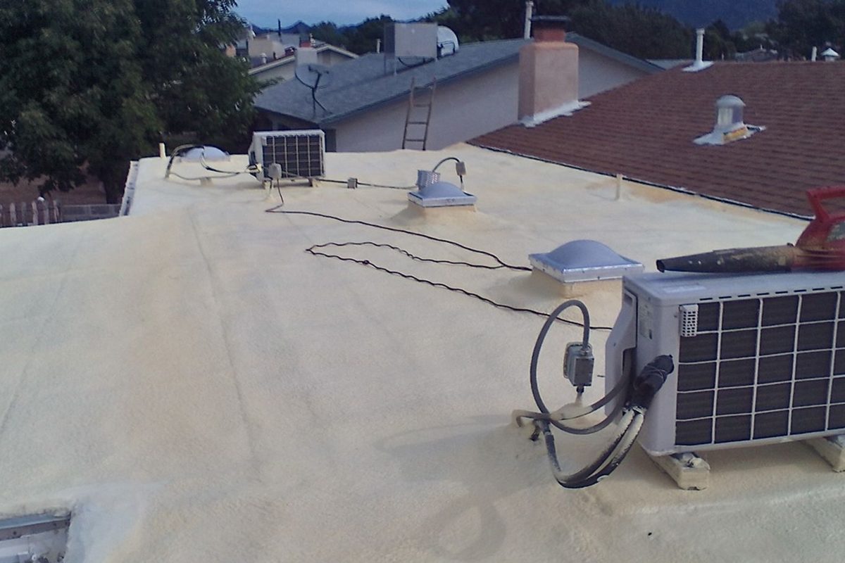 Coated spray foam roof on a Santa Fe home with rooftop equipment