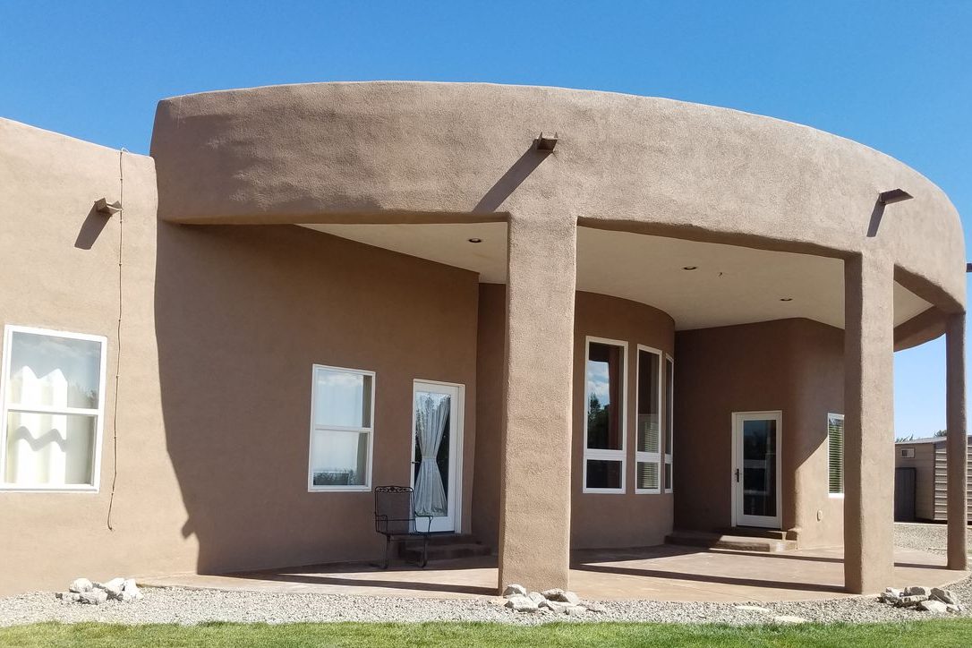 Sedillo Hills estate with a curved portal and new stucco finish over spray foam walls